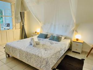 Una cama o camas en una habitación de Sous les Tropiques…Vue mer