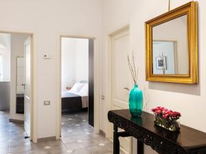 Zimmer mit einer Vase auf einem Tisch und einem Spiegel in der Unterkunft San Domenico Apartment in Taormina
