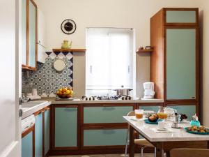 a kitchen with blue cabinets and a table with fruits on it at San Domenico Apartment in Taormina