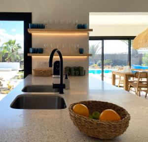 a kitchen counter with a sink and a basket of fruit at Modern villa in Lajares with private pool in La Oliva