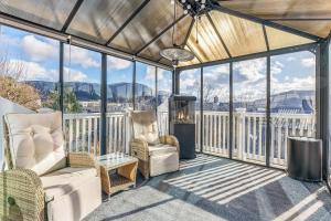 a screened in porch with chairs and a fireplace at Casa Knott 4 Bedroom in Ulstein