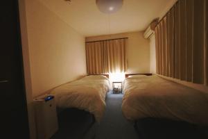 a hotel room with two beds and a window at 木漏の宿 in Osaka
