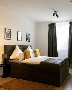 a bedroom with a bed with yellow pillows and a window at City Apartments Trier Suite 5 in Trier