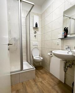 a bathroom with a shower and a toilet and a sink at City Apartments Trier Suite 5 in Trier