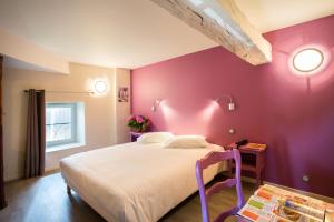 een slaapkamer met een groot bed met paarse muren bij Hotel Restaurant Le Sully in Saint-Saud-Lacoussière