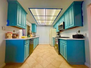 a kitchen with blue cabinets and a white refrigerator at Warm nest Rancho Cucamonga in Rancho Cucamonga