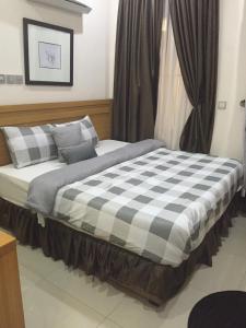 a large bed in a bedroom with a window at Greens Manor VI in Lagos