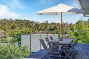 a table and chairs with an umbrella on a deck at Rye Beach House - Sunset Views in Rye