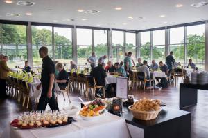 een groep mensen die aan tafel zitten in een restaurant bij Vingsted Hotel & Konferencecenter in Bredsten