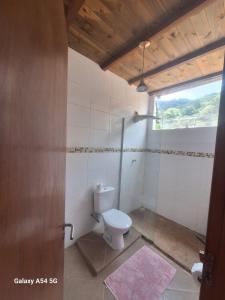 een badkamer met een toilet en een raam bij Alma Surf House in Boicucanga +29 foto's
