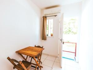 Una mesa y sillas en una habitación con ventana. en Pousada Sol Nascente, en Ubatuba
