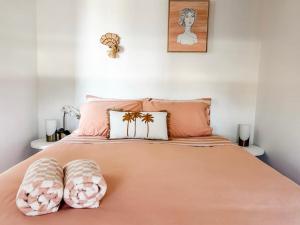 a bed with two pink pillows on top of it at Villa Nura in Lake Illawarra
