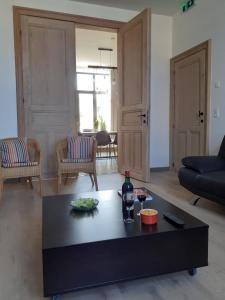 a living room with a black coffee table with a bottle of wine at Huyze Vinck in Veurne +36 photos