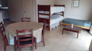 a living room with a table and chairs and a bed at DEPARTAMENTo CÉNTRICO in Lobos