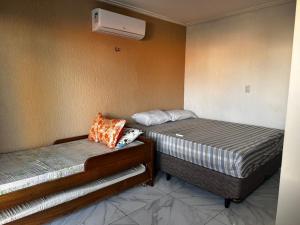 two beds sitting next to each other in a room at Lessa imob in Salinópolis