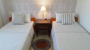 a room with two beds and a table with a lamp at Santa Teresa, hospedaje rural in Antonio Carboni +27 photos