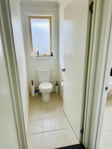 a bathroom with a toilet and a window at Blackmans Bay Villa in Kingston Beach +7 photos