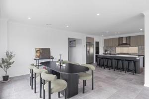 a kitchen with a round table and chairs in a room at Golf Club Mystic Tides by Ready Set Stay in San Remo