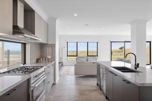 a kitchen with a sink and a stove top oven at Golf Club Mystic Tides by Ready Set Stay in San Remo
