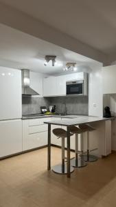 a kitchen with white cabinets and a table with a sink at Casa Yanelis in Antigua