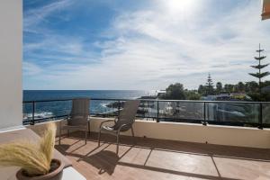 a balcony with two chairs and a view of the ocean at Villa Roque in São Roque