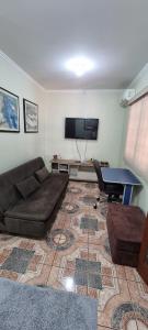 a living room with a couch and a flat screen tv at Casa no centro aproveite o melhor de Foz in Foz do Iguaçu