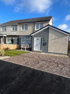 a house with a white door and a driveway at Dunmuir House 4 Bedroom 2 bathroom House & Garden in Denny in Falkirk
