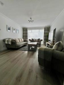 a living room with a couch and a table at Dunmuir House 4 Bedroom 2 bathroom House & Garden in Denny in Falkirk
