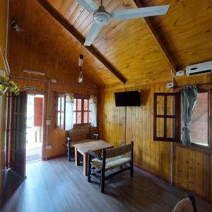 a dining room with a table and a ceiling fan at Las Torres del Sol in Villa Lía