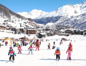 a group of children on skis in the snow at Hotel Bristol in Saas-Fee