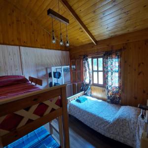 a bedroom with a bed and a window in a cabin at Las Torres del Sol in Villa Lía