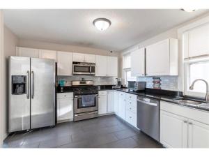une cuisine avec des armoires blanches et des appareils en acier inoxydable dans l'établissement Lyndale Oasis, à Minneapolis