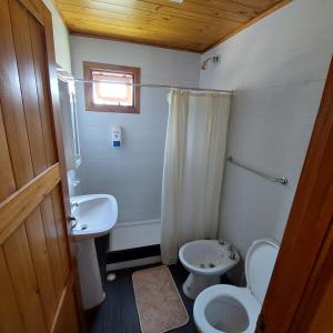 a small bathroom with a toilet and a sink at Las Torres del Sol in Villa Lía