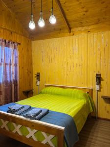 a bedroom with a bed with green sheets and wooden walls at Las Torres del Sol in Villa Lía +30 photos