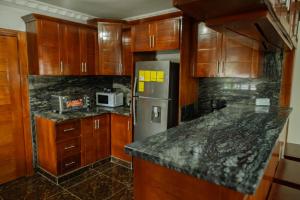Una cocina con gabinetes de madera y un refrigerador de acero inoxidable. en Etage prive dans maison , très chaleureux, en Los Paredones 9 fotos más