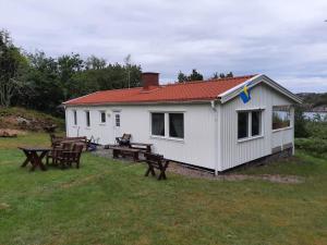 a white house with picnic tables in front of it at 5 star holiday home in Mastrand in Marstrand