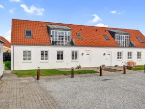 ein großes weißes Haus mit einem orangefarbenen Dach in der Unterkunft Cozy Retreat in Lokken - By Traum Ferienwohnungen in Løkken