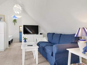 a living room with a blue couch and a tv at Cozy Retreat in Lokken - By Traum Ferienwohnungen in Løkken