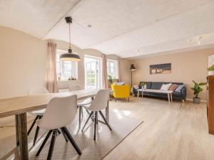 a dining room and living room with a table and chairs at Charming Seaside Escape - By Traum Ferienwohnungen in Hjørring