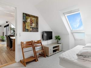 a bedroom with a bed and a tv and a chair at Luxury Retreat in Lokken - By Traum Ferienwohnungen in Løkken