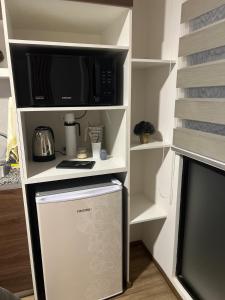 a small kitchen with a microwave and a refrigerator at Cómodo y confortable Estudio in Cochabamba +7 photos