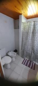 a bathroom with a toilet and a shower curtain at Tu Casa en la Naturaleza in San Carlos de Bariloche