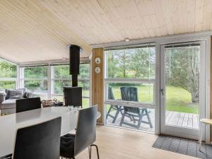 a living room with a table and chairs and sliding glass doors at Holiday home with spacious garden in Løkken