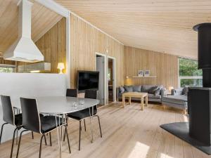 a living room with a table and a couch at Holiday home with spacious garden in Løkken +4 photos