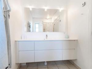 a white bathroom with a sink and a mirror at Cozy Coastal Retreat - By Traum Ferienwohnungen in Løkken +21 photos