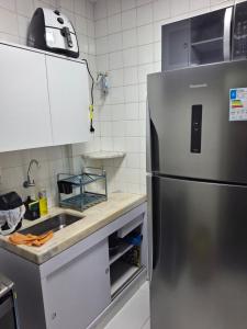 ヴィトーリアにあるApartamento na Praia do cantoのキッチン(ステンレス製の冷蔵庫付)
