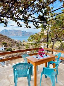 a wooden table and chairs with a view of the ocean at Emborios Views - Studio in Emborios +10 photos