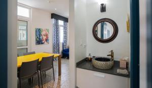 una sala da pranzo con tavolo giallo e specchio di Money Heist Casa del Papel Apt a Città di Panama