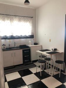 a kitchen with a black and white checkered floor at Casa Acaraí in São Francisco do Sul
