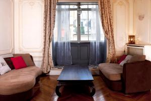 uma sala de estar com dois sofás e uma mesa em Haussmann Opera em Paris